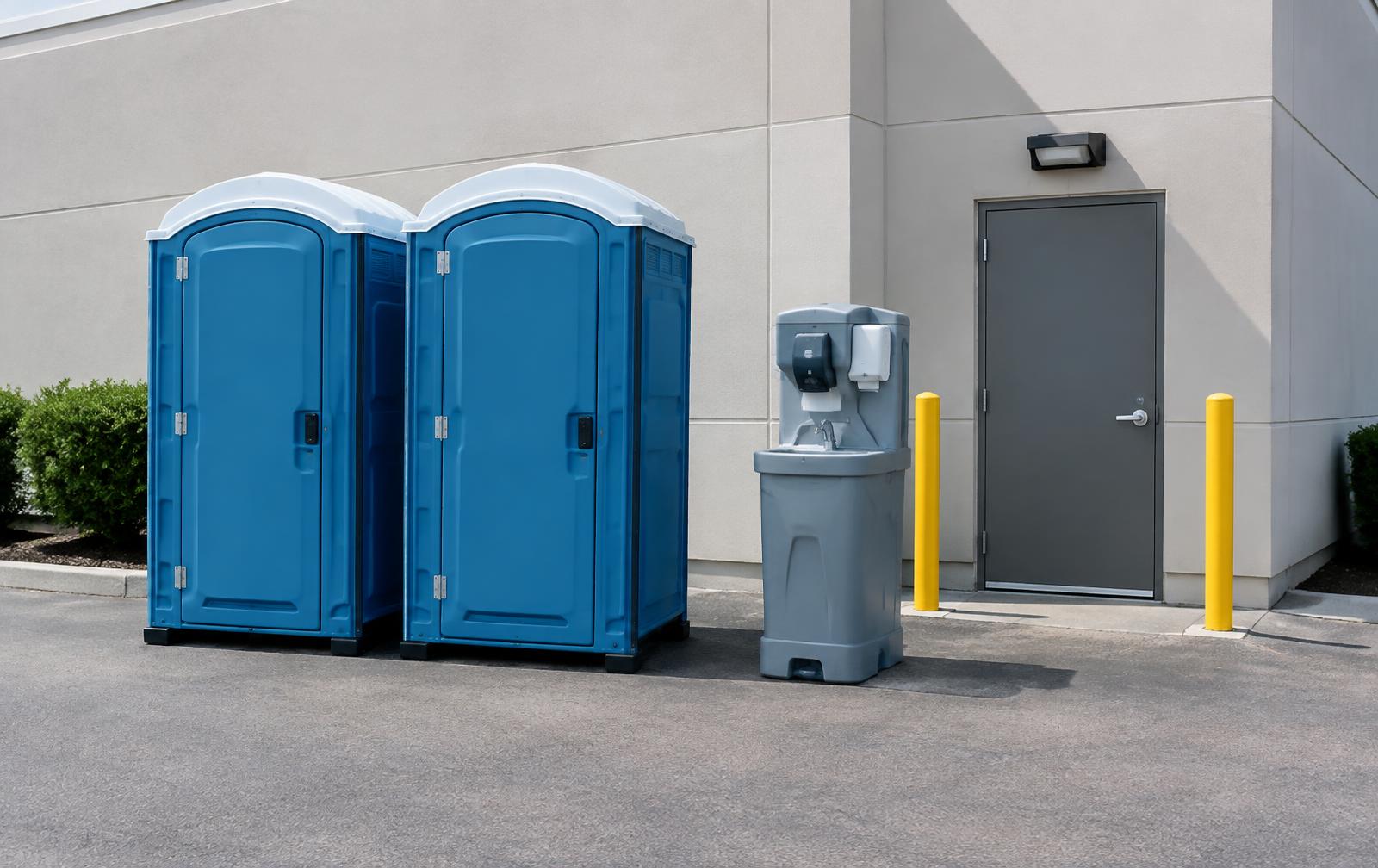 Temporary sanitation units beside a commercial building during a plumbing outage