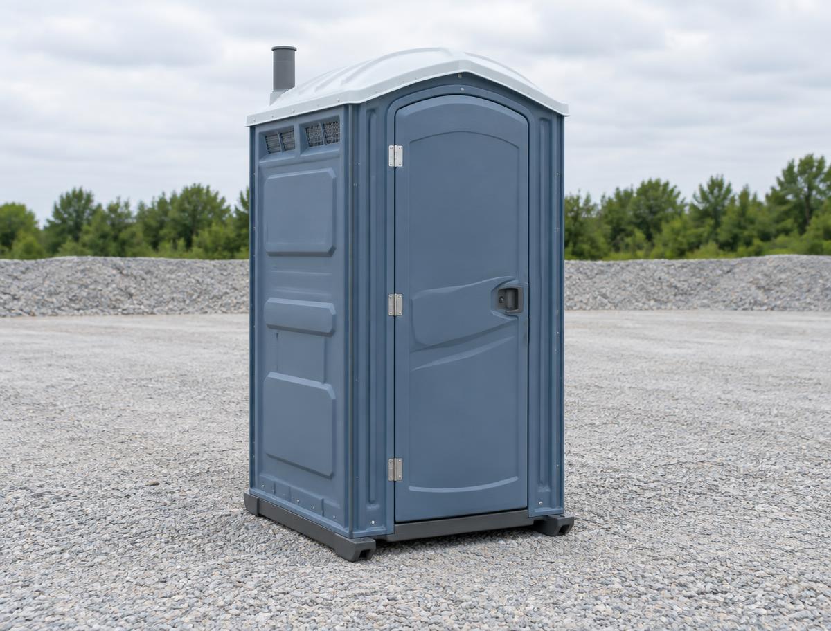 Single blue-gray standard portable toilet on a gravel yard